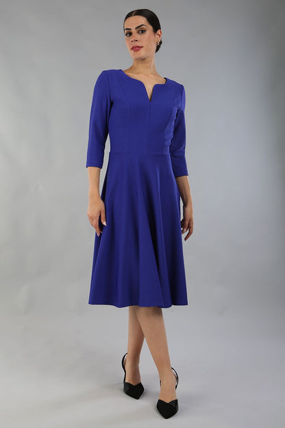 model wearing a diva catwalk Seed Corsham Swing Dress with 3/4 sleeve and below the knee length with v slit detail on the neckline in palace blue colour