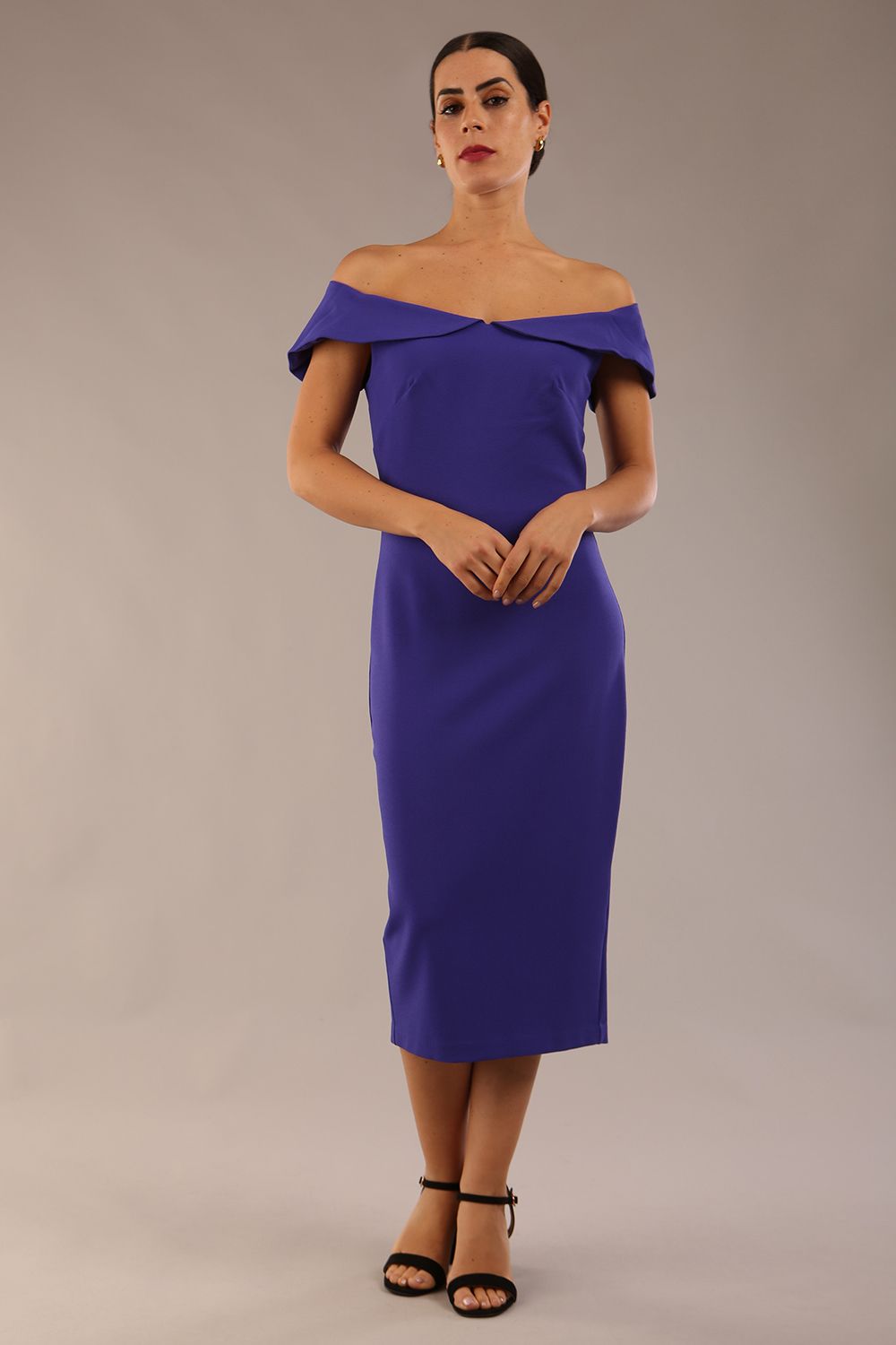 brunette model wearing diva catwalk juilet midaxi pencil sleeveless off shoulder dress with open neck and folded collar in colour spectrum indigo front