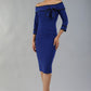 model wearing a diva catwalk Paige Bi-Stretch Dress with 3/4 sleeve, knee length, Fold over off-shoulder neckline with bow detail and with Contrast piping on sleeve cuffs and neckline in Cobalt Blue and black colour