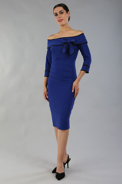 model wearing a diva catwalk Paige Bi-Stretch Dress with 3/4 sleeve, knee length, Fold over off-shoulder neckline with bow detail and with Contrast piping on sleeve cuffs and neckline in Cobalt Blue and black colour