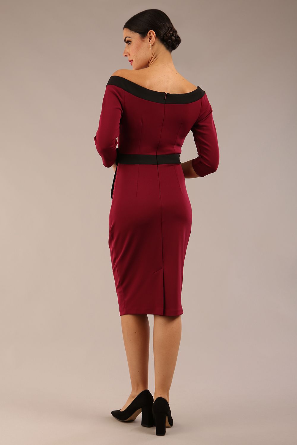 brunette model wearing diva catwalk luma pencil skirt dress with contrasting bow off shoulder with sleeves in blissful burgundy back