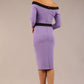 brunette model wearing diva catwalk luma pencil skirt dress with contrasting bow off shoulder with sleeves in Violet Bloom back image