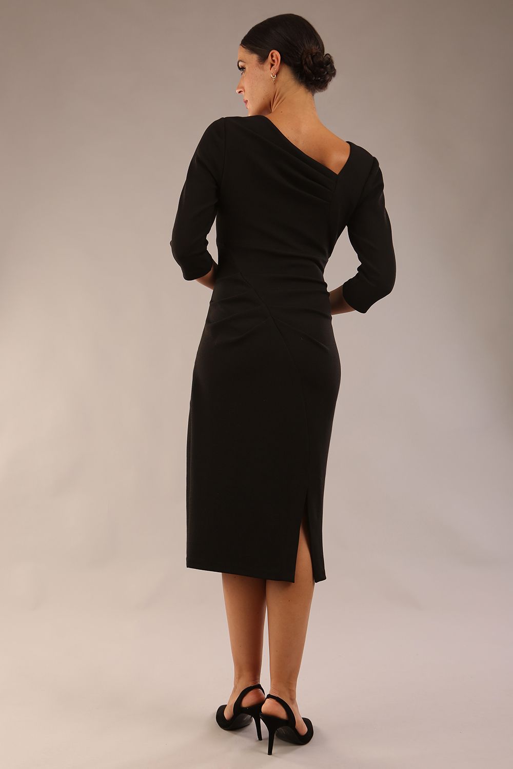 model wearing a diva catwalk Rococo 3/4 Sleeved Pencil Dress with asymmetric neckline with pleating details and 3/4 sleeves length and knee length in black colour