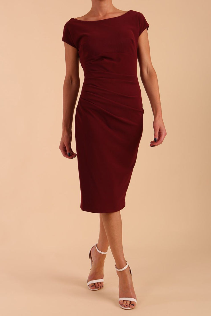 Model wearing Diva Catwalk Polly Rounded Neckline Pencil Cap Sleeve Dress with pleating across the tummy area in Cabaret Burgundy front