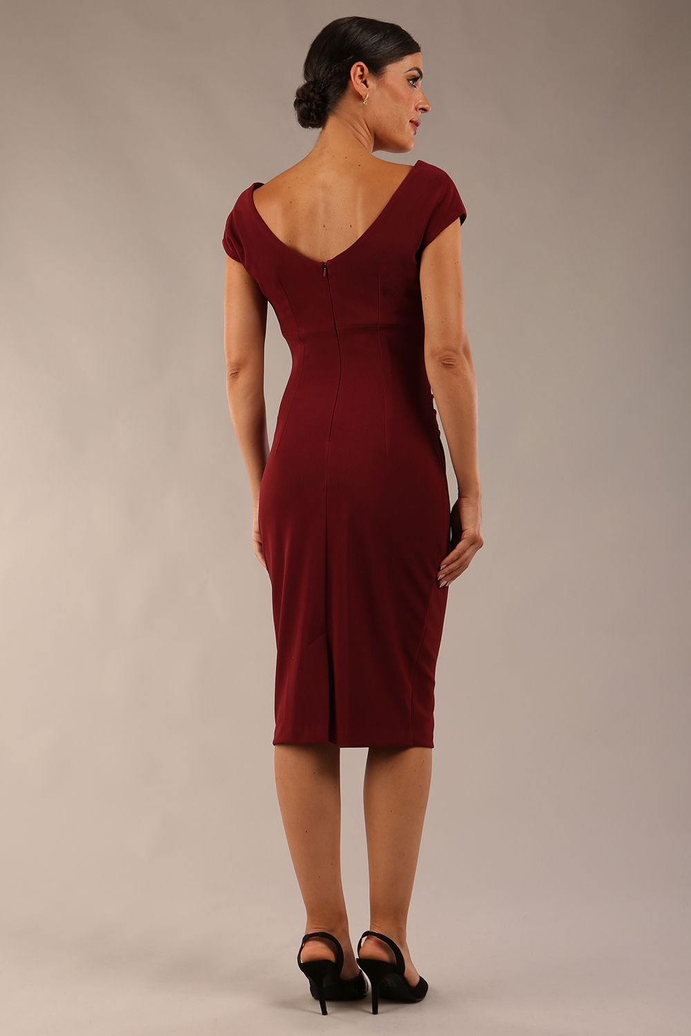 Model wearing Diva Catwalk Polly Rounded Neckline Pencil Cap Sleeve Dress with pleating across the tummy area in Cabaret Burgundy back