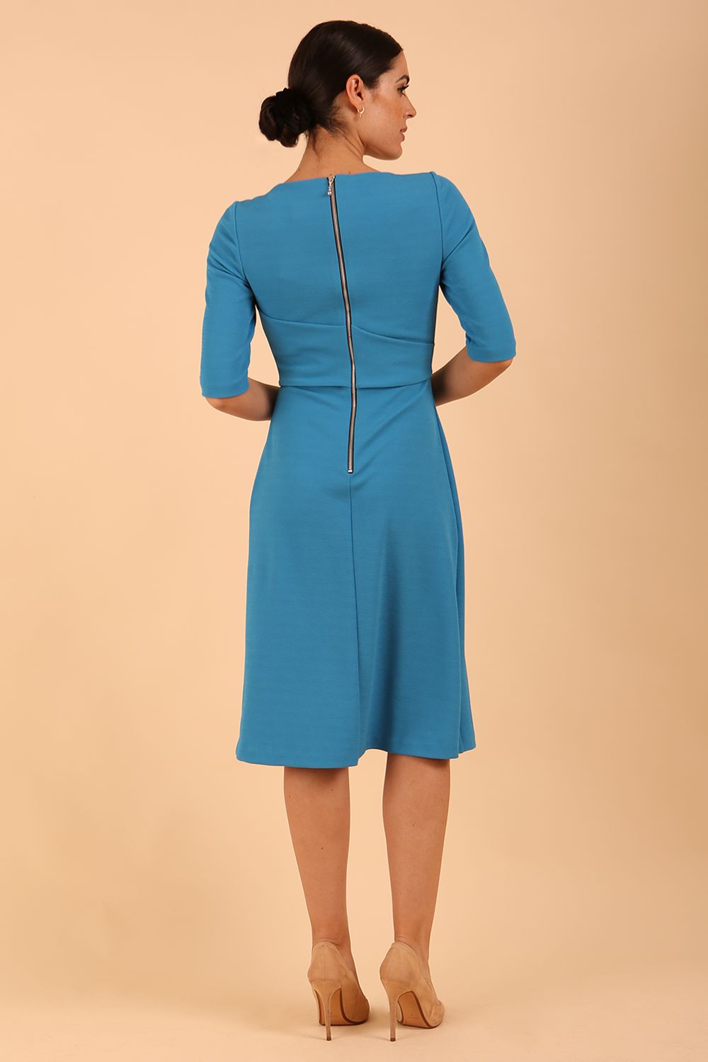 model wearing a Tarifa Elbow Sleeve Swing Dress 3/4 sleeves and knee length in malibu blue colour back