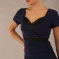 model is wearing a diva catwalk dress in navy blue with black satin detail contrast on the neckline and waistband short sleeves and pleating details with knee length