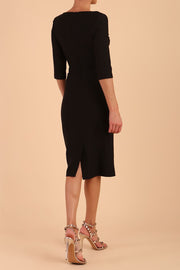 model wearing seed couture royale pencil skirt dress with pleating across the tummy area with rounded neckline with a split in the middle and 3 4 sleeve in Black colour back
