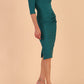 model wearing seed couture royale pencil skirt dress with pleating across the tummy area with rounded neckline with a split in the middle and 3 4 sleeve in Pacific Green colour front side