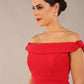 brunette model wearing a diva catwalk cloud pencil fitted flattering dress off shoulder sleeveless with detail with pleating around the front in scarlet red front close up