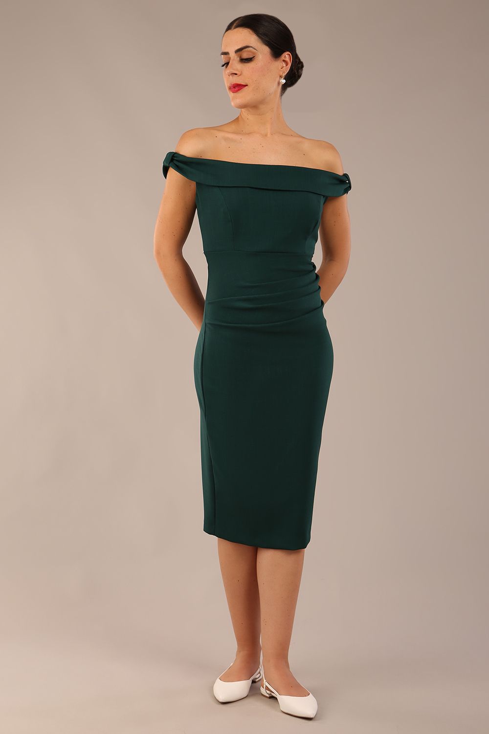 brunette model wearing a diva catwalk cloud pencil fitted flattering dress off shoulder sleeveless with detail with pleating around the front in forest green front