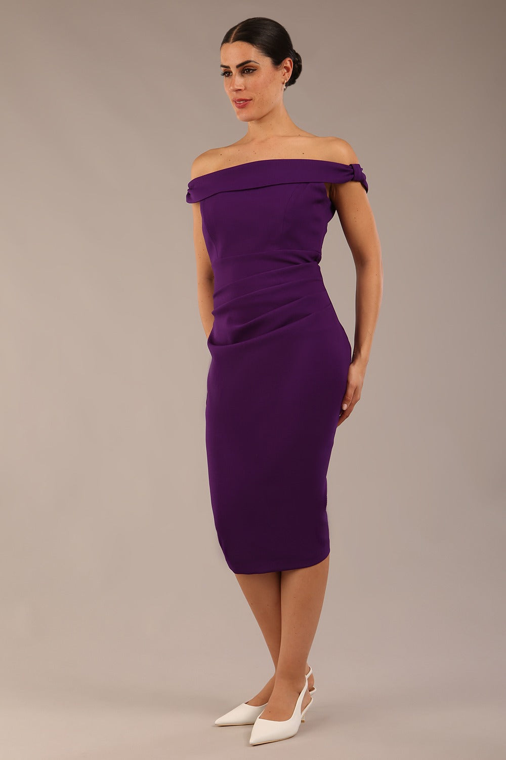 brunette model wearing a diva catwalk cloud pencil fitted flattering dress off shoulder sleeveless with detail with pleating around the front in deep purple front