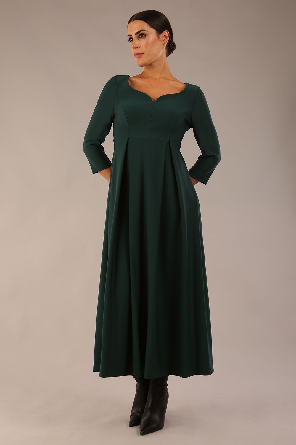 Brunette Model is wearing 3/4 sleeve sweetheart neckline swing forest green dress