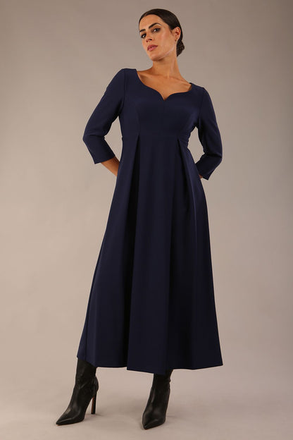 Brunette Model is wearing 3/4 sleeve sweetheart neckline swing navy blue dress