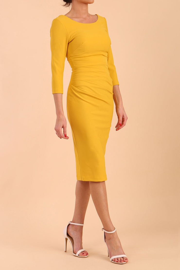 model is wearing diva catwalk polly sleeved pencil dress with low rounded neckline at the back in Mustard Yellow side