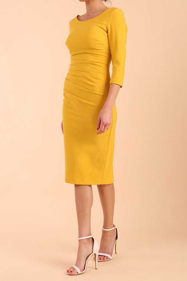 model is wearing diva catwalk polly sleeved pencil dress with low rounded neckline at the back in Mustard Yellow side