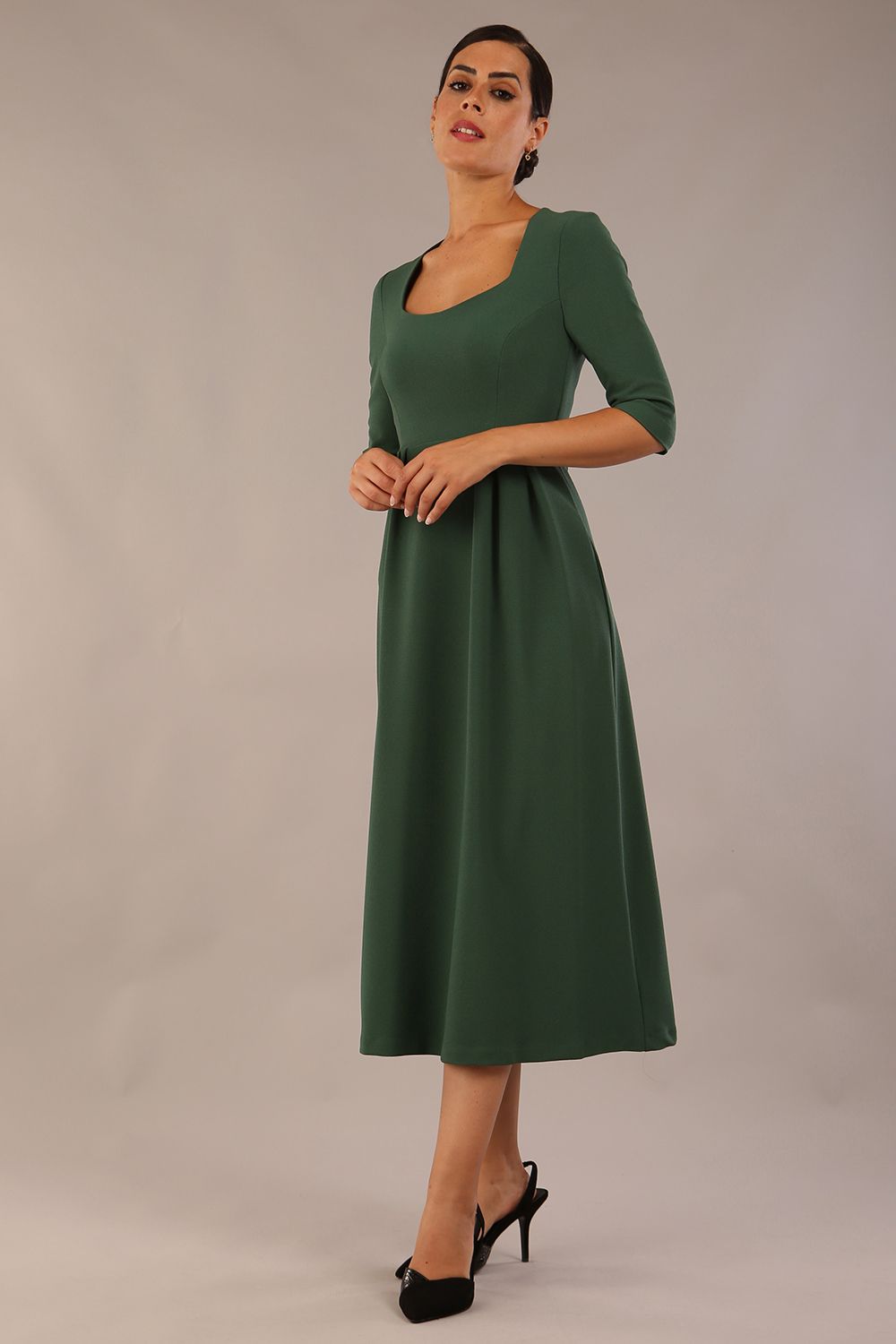 model wearing a diva catwalk Padstow Midi A-line Dress elbow length sleeves and midi length with empire waistline in hunter green colour