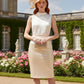 model wearing diva ashford faux leather pencil skirt in ivory front and large beige hat standing in a garden with classical architecture.
