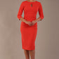 model wearing diva catwalk ubrique pencil dress with a keyhole detail and sleeves in Grenadine Orange  (Grenadine Orange)