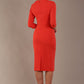 model wearing diva catwalk ubrique pencil dress with a keyhole detail and sleeves in Grenadine Orange  (Grenadine Orange)