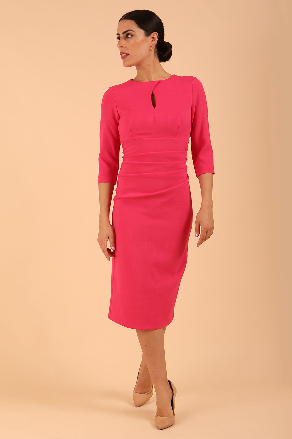 brunette model wearing diva catwalk ubrique pencil dress with a keyhole detail and sleeves in fuchsia pink front