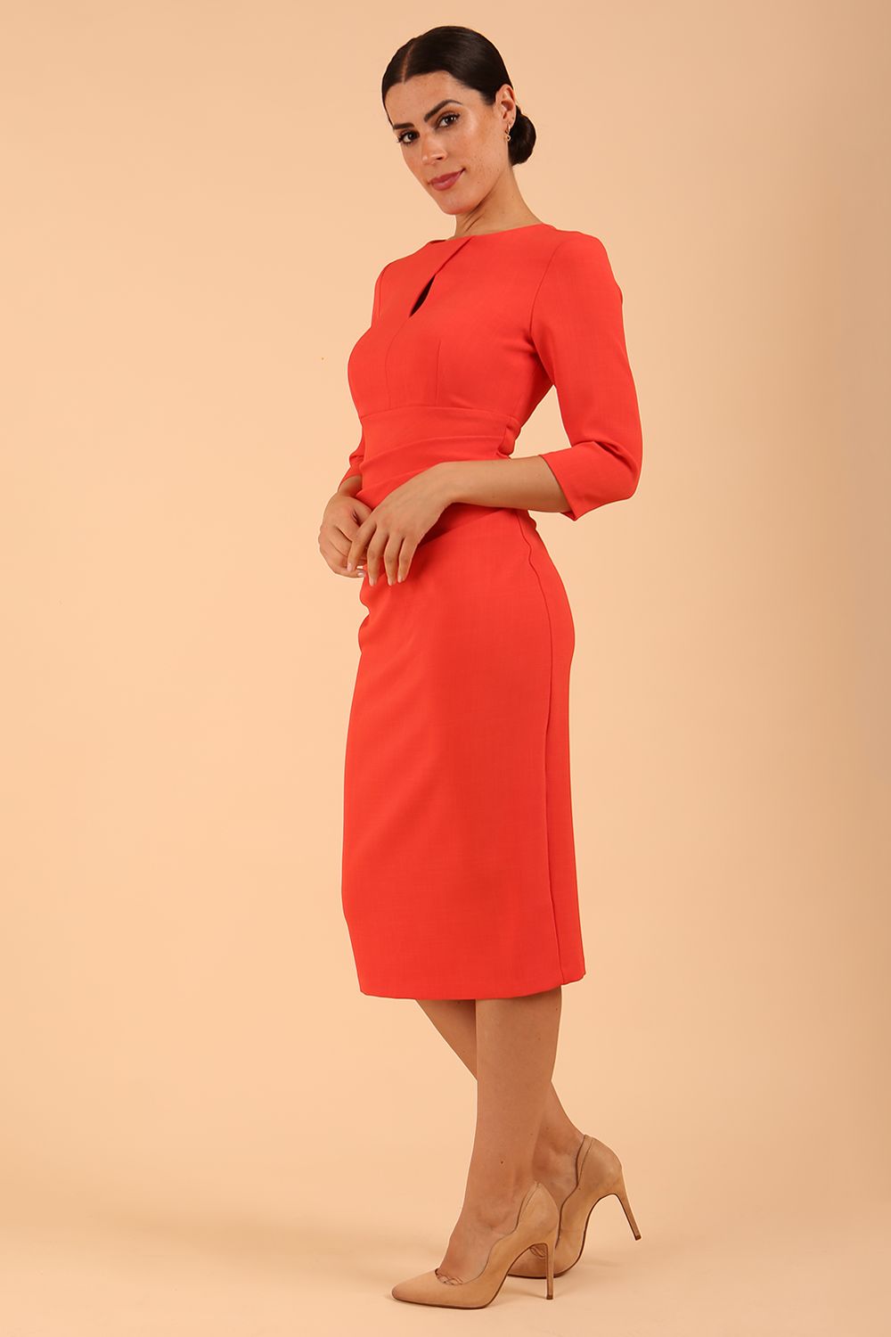 brunette model wearing diva catwalk ubrique pencil dress with a keyhole detail and sleeves in Grenadine Orange colour