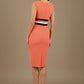 Woman wearing a coral dress with black and white band details on a beige background (Sea Coral & Black)