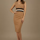 Woman wearing a tan dress with black and white accents on a beige background (Camel & Black)