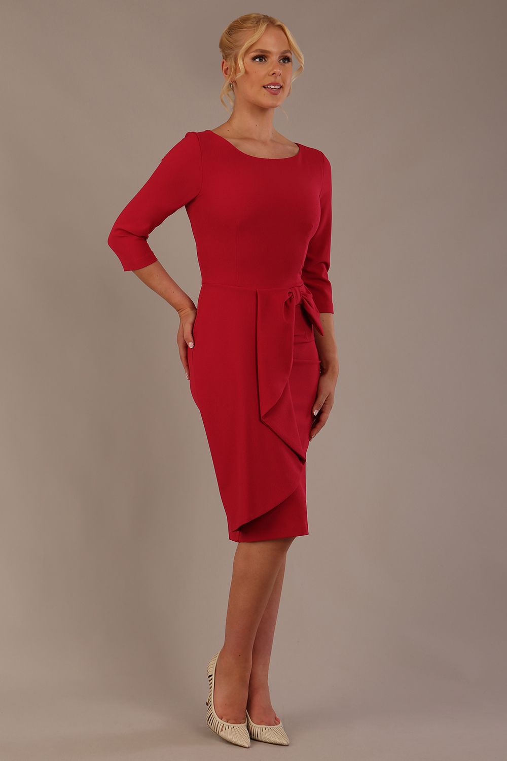 model is wearing diva catwalk jacky dress with rounded neckline 3/4 sleeve and bow detail on the waist in Dazzle pink front view