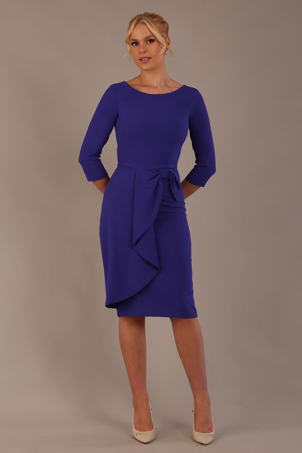 model is wearing diva catwalk jacky dress with rounded neckline 3/4 sleeve and bow detail on the waist in spectrum indigo front view