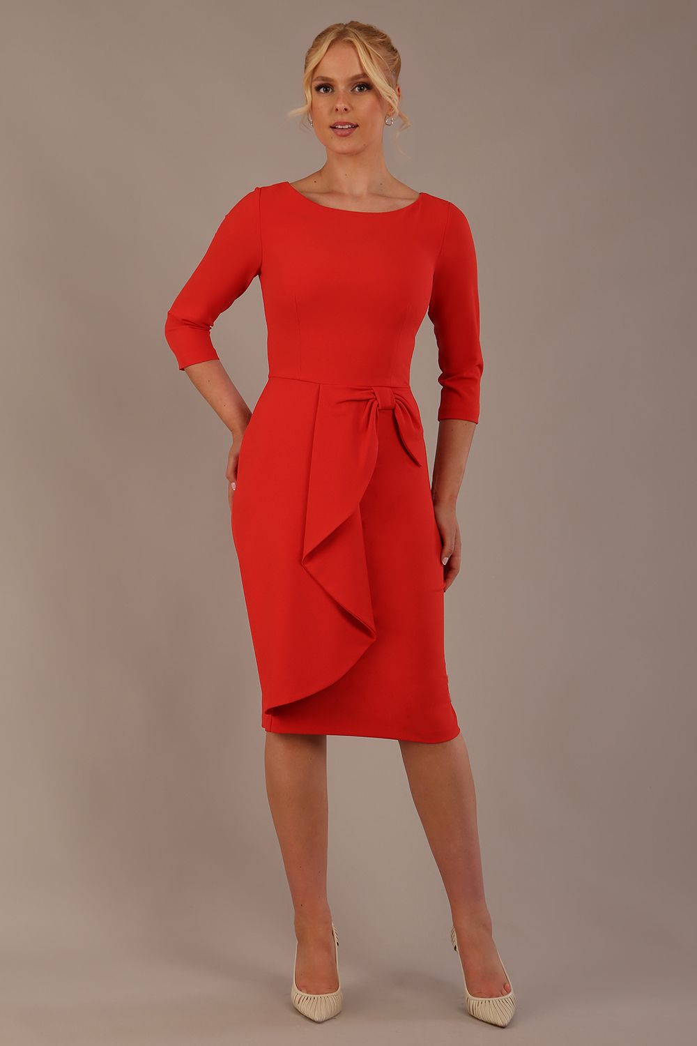 model is wearing diva catwalk jacky dress with rounded neckline 3/4 sleeve and bow detail on the waist in fiesta orange front view