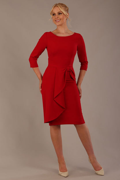 model is wearing diva catwalk jacky dress with rounded neckline 3/4 sleeve and bow detail on the waist in scarlet red front view