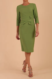 Model wearing diva catwalk Seed Andante Pencil Skirt Dress with 3/4 sleeve and bow detail at waistline in Citrus Green front 