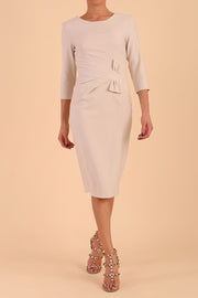 Model wearing diva catwalk Seed Andante Pencil Skirt Dress with 3/4 sleeve and bow detail at waistline in Sandy Cream front 