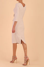Model wearing diva catwalk Seed Andante Pencil Skirt Dress with 3/4 sleeve and bow detail at waistline in Sandy Cream back