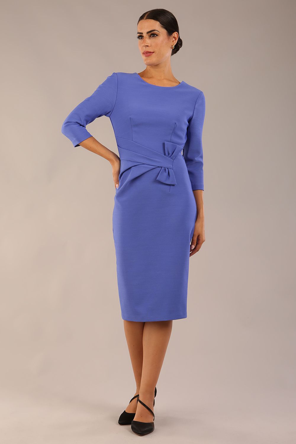 Model wearing diva catwalk Seed Andante Pencil Skirt Dress with 3/4 sleeve and bow detail at waistline in Thistle Blue front 