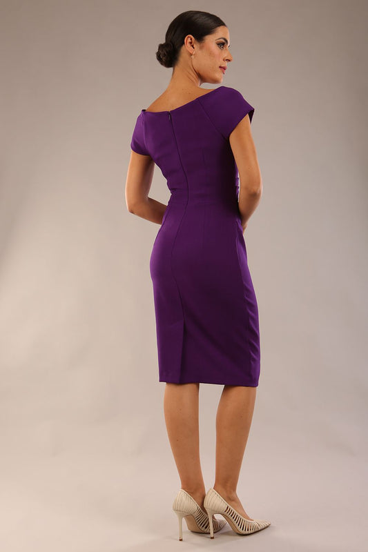 Model is wearing an off shoulder pencil dress by Diva Catwalk in deep purple