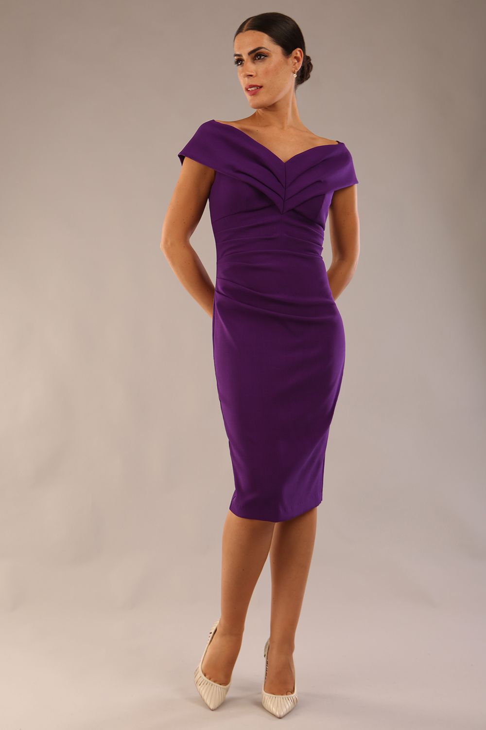 Model is wearing an off shoulder pencil dress by Diva Catwalk in deep purple