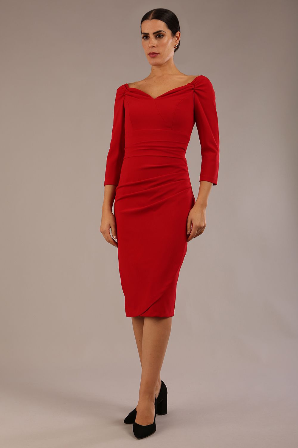 brunette model wearing diva catwalk evening pencil dress off shoulder with sleeves and pleated pencil skirt in colour scarlet red front