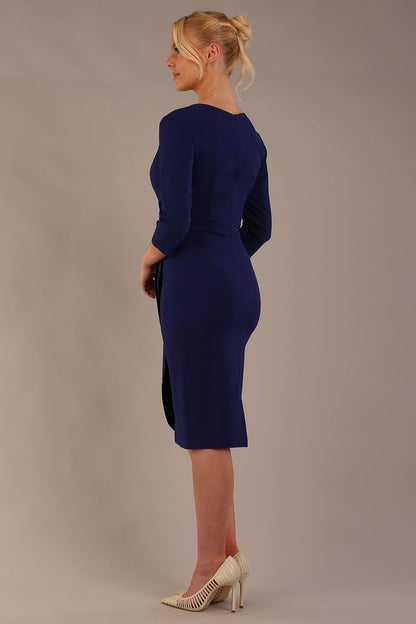 model wearing diva catwalk elan elegant black dress with 3 4 sleeves with a tie detail and asymmetrical closing back (Oxford Blue)