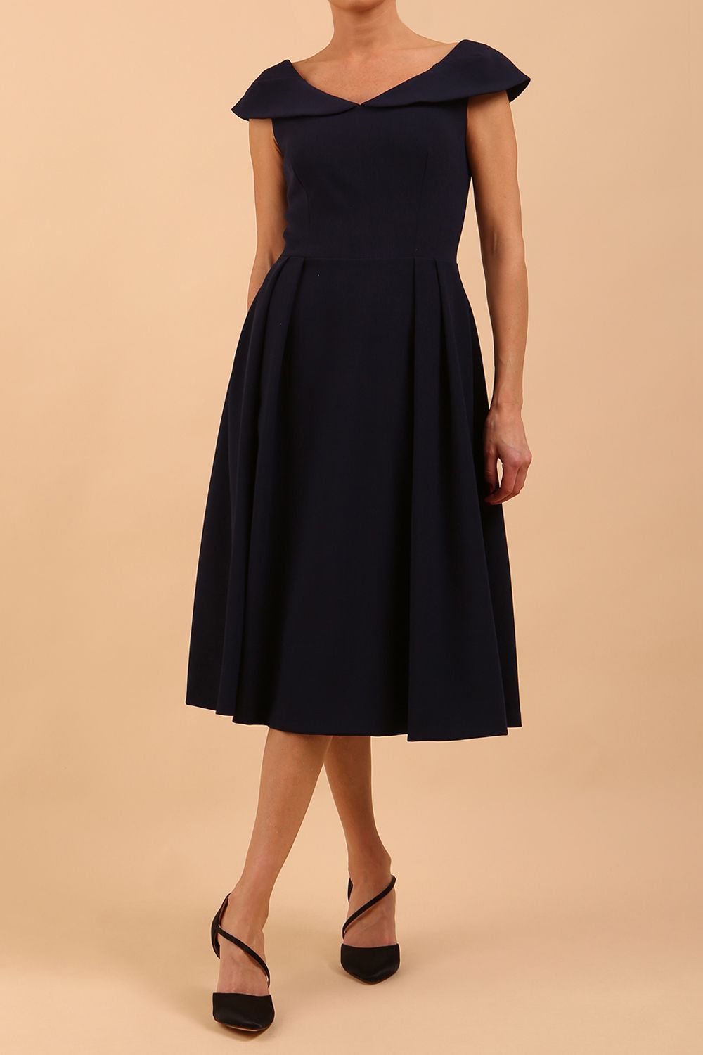 Model wearing the Diva Chesterton Sleeveless dress with oversized collar detail and swing pleated skirt in navy blue front image