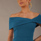 model wearing diva catwalk vegas calf length Teal midaxi dress with wide bardot neckline and open shoulders with a large opening at the front of the skirt with pleating coming down long skirt front close-up (Tropical Teal)