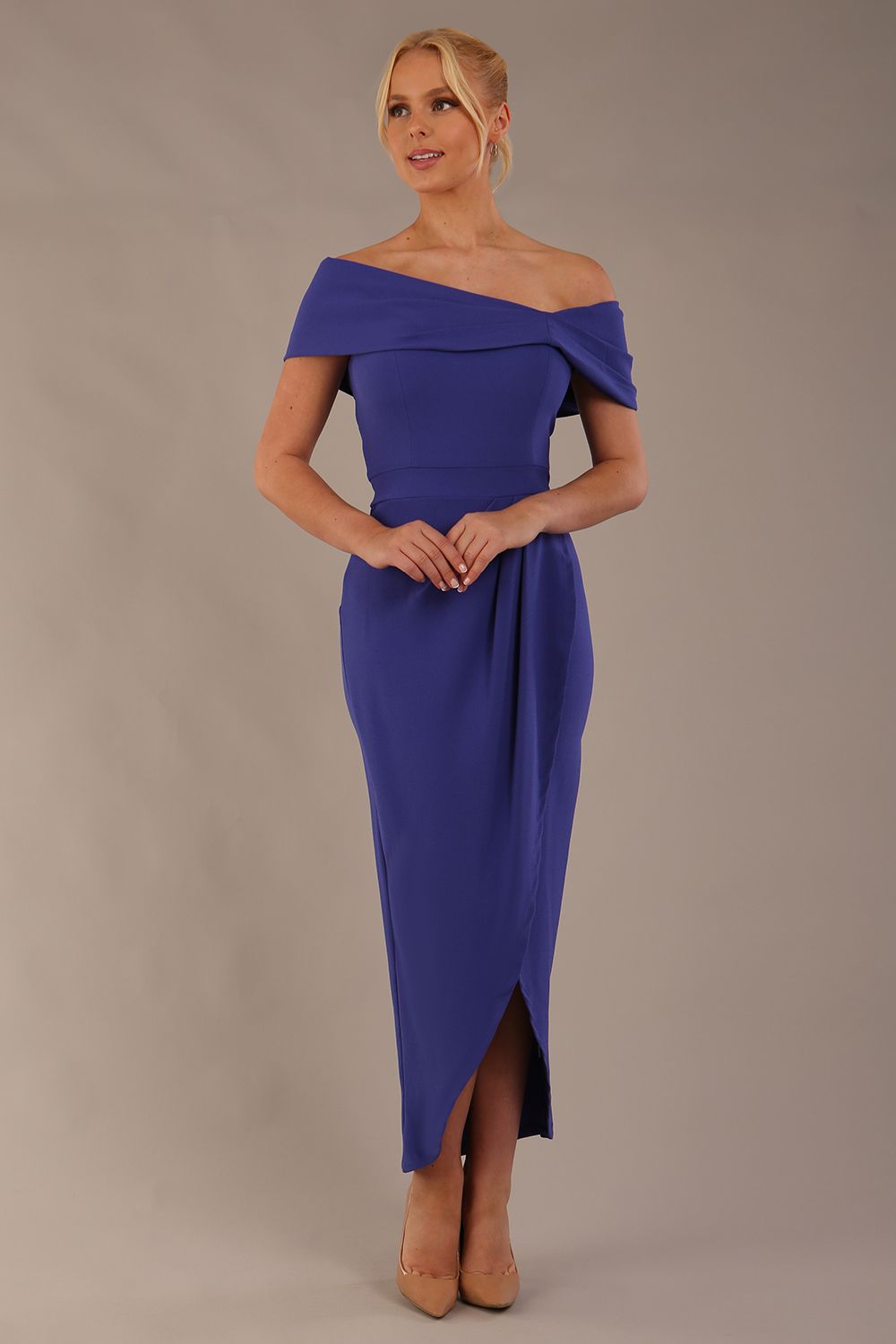 model wearing diva catwalk vegas calf length spectrum indigo midaxi dress with wide bardot neckline and open shoulders with a large opening at the front of the skirt with pleating coming down long skirt front (Spectrum Indigo)