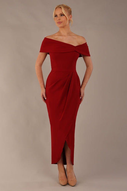 model wearing diva catwalk vegas calf length rosewood red midaxi dress with wide bardot neckline and open shoulders with a large opening at the front of the skirt with pleating coming down long skirt front (Rosewood Red)