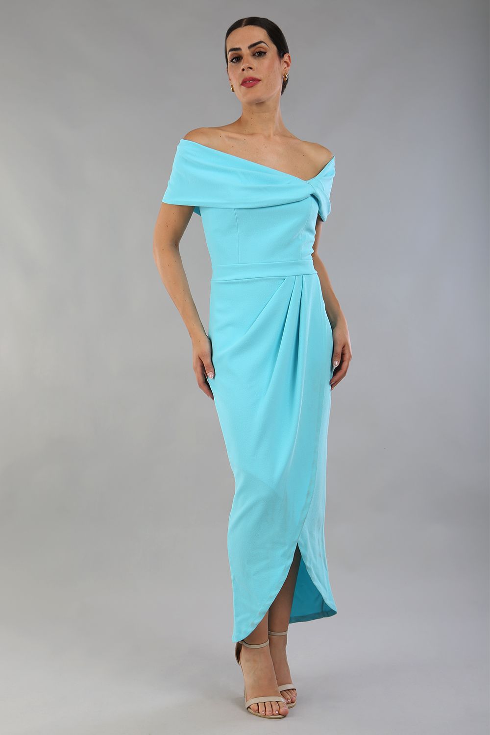 model wearing diva catwalk vegas calf length midaxi dress with wide bardot neckline and open shoulders with a large opening at the front of the skirt with pleating coming down long skirt front in turquoise