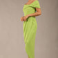 brunette model wearing diva catwalk vegas calf length lime green midaxi dress with wide bardot neckline and open shoulders with a large opening at the front of the skirt with pleating coming down long skirt front 