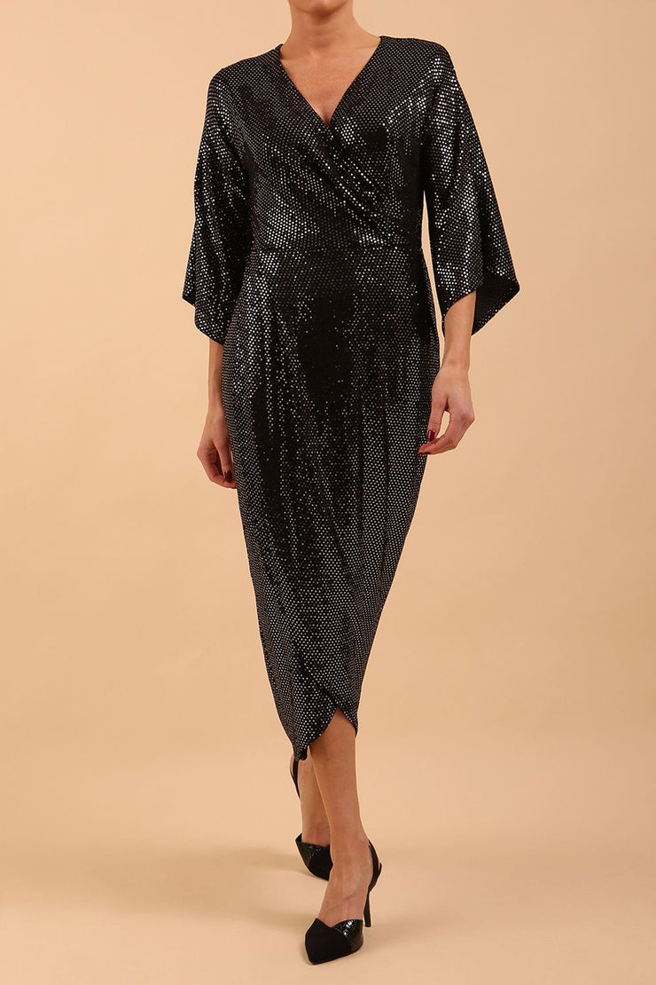 Brunette model wearing diva catwalk Glitterati Midaxi Sparkle Dress in Black in Jersey sparkle and ITY lining with wrap dress style and 3/4 length bell sleeves front