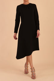 model is wearing diva catwalk dartington asymmetric skirt midaxi long sleeve dress with rounded pleated neckline a-line style in black front