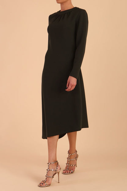 model is wearing diva catwalk dartington asymmetric skirt midaxi long sleeve dress with rounded pleated neckline a-line style in obsidian green front