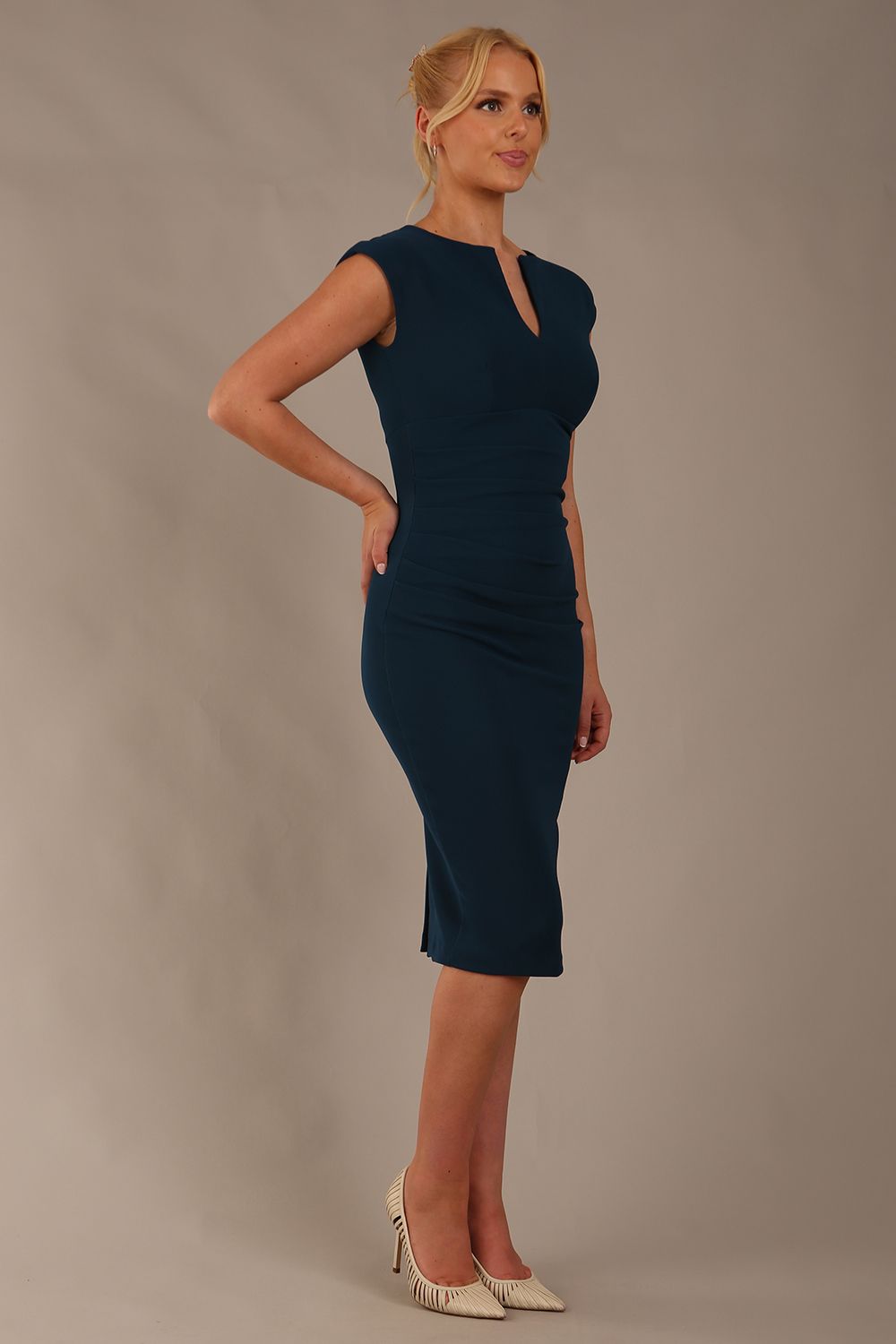 blonde model wearing diva catwalk lydia sleeveless pencil flattering fitted plain dress with split neckline and pleating across the body teal front (Autumn Teal)